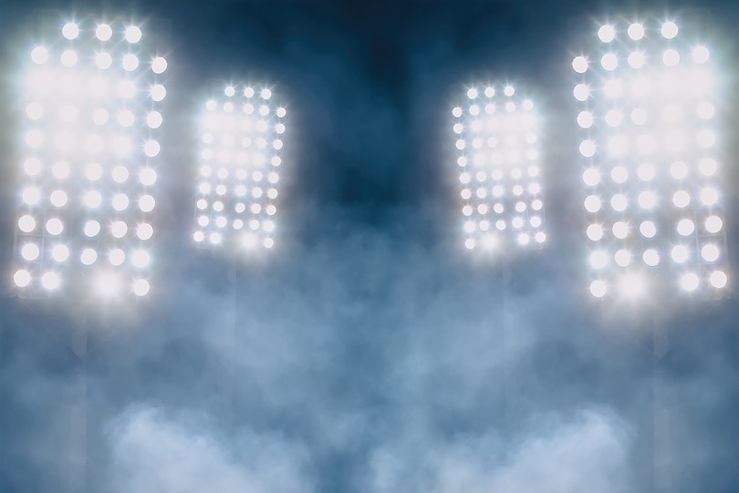 Four Stadium Floodlights Behind Mist