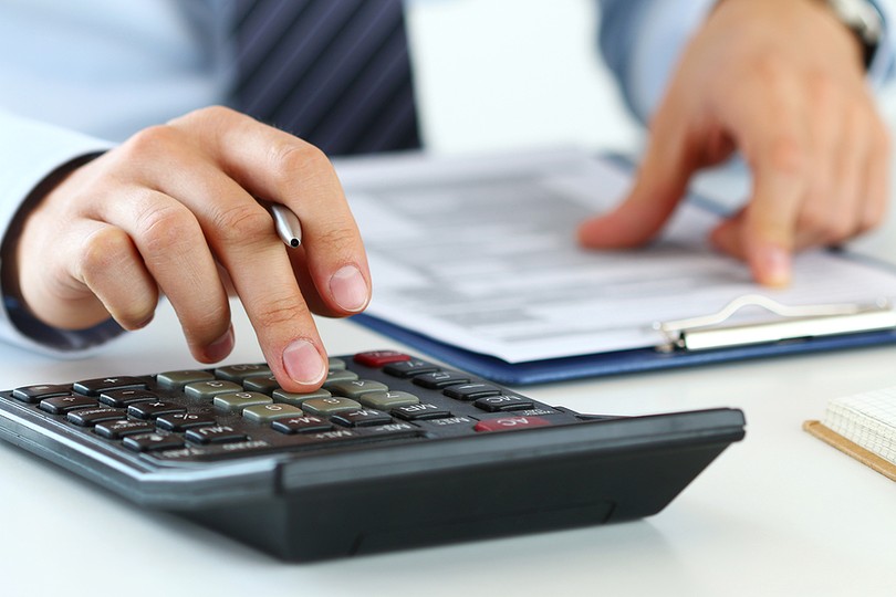 Businessman with Clipboard Using Calculator